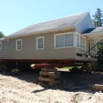 24x40ft cottage raised and rolled out of way. New foundation is completed and cottage is being rolled back onto the foundation.