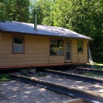 24x32ft cottage in Point Clark, 4 steel beams are being installed under cottage and a large deck was built at the front of the cottage.