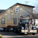 House 30x40ft was relocated 10 blocks away from downtown Kincardine along the river. Land used for a teaching school/office. House being navigated down tight streets.