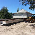 24x40ft cottage raised and rolled out of way. New foundation is completed and cottage is being rolled back onto the foundation.